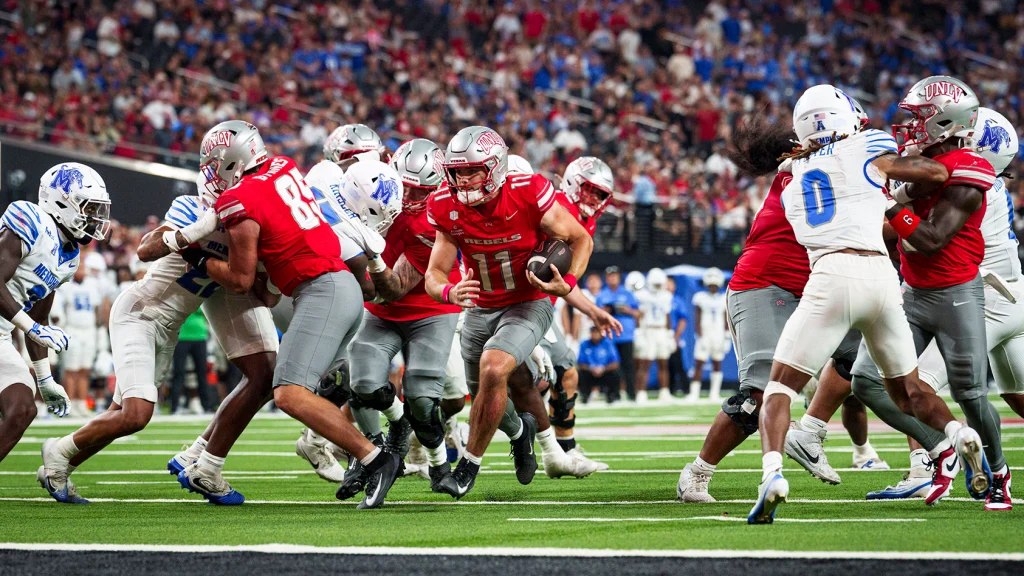 Jackson Arnold carrying the ball behind UNLV blockers against Memphis in August 2026
